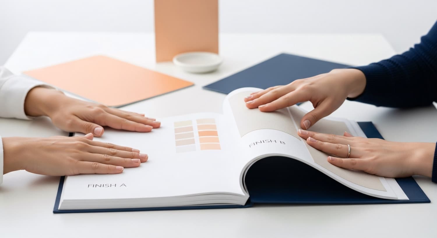 Two people reviewing a book of colour and material swatches together during a design session.